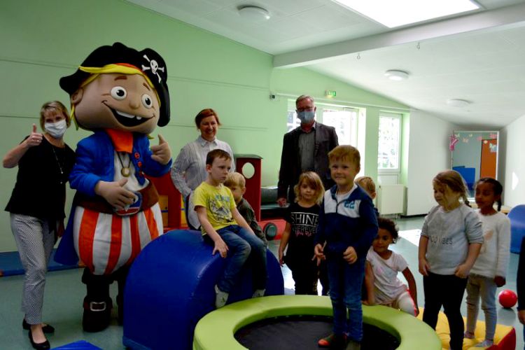 v.l.: Frau Lange (Vorstandssekretärin Volksbank), Flint (Maskottchen), Ulrike Wefer (Leitung Kita), Wolfgang Mann (Geschäftsführer), Kinder der Löwengruppe