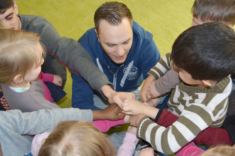 Simon Macherski und Arnau Triginer zeigen den Kindern das Eisbären Begrüßungsritual